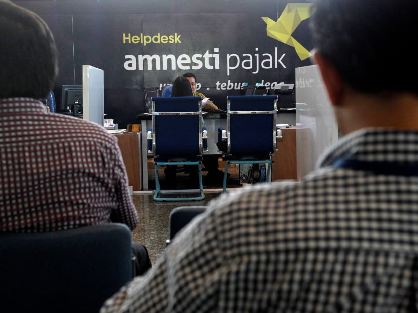People wait at a help desk for tax amnesty at the country's tax headquarters in Jakarta, Indonesia, on Sept 23, 2016. Photo: Reuters