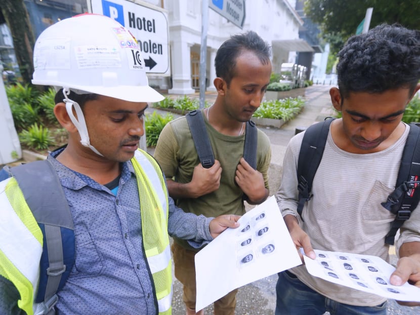 Construction workers looking at the mug shots of twenty-seven Bangladeshi foreign workers, who were arrested here under the Internal Security Act, on Jan 20, 2016. Photo: Ernest Chua/TODAY