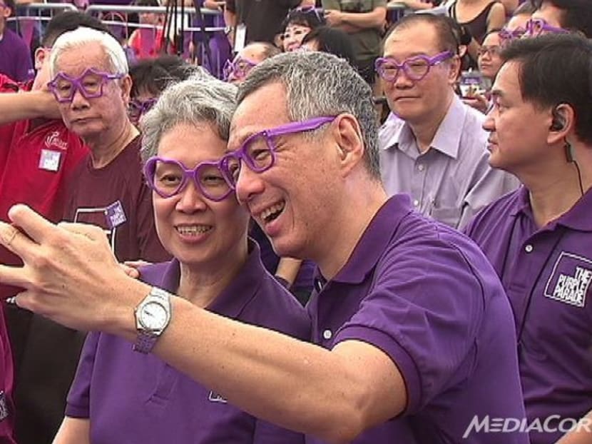 Prime Minister Lee Hsien Loong taking a picture with his wife Ho Ching at the Purple Parade on Saturday (Oct 31). Photo: CHANNEL NEWSASIA
