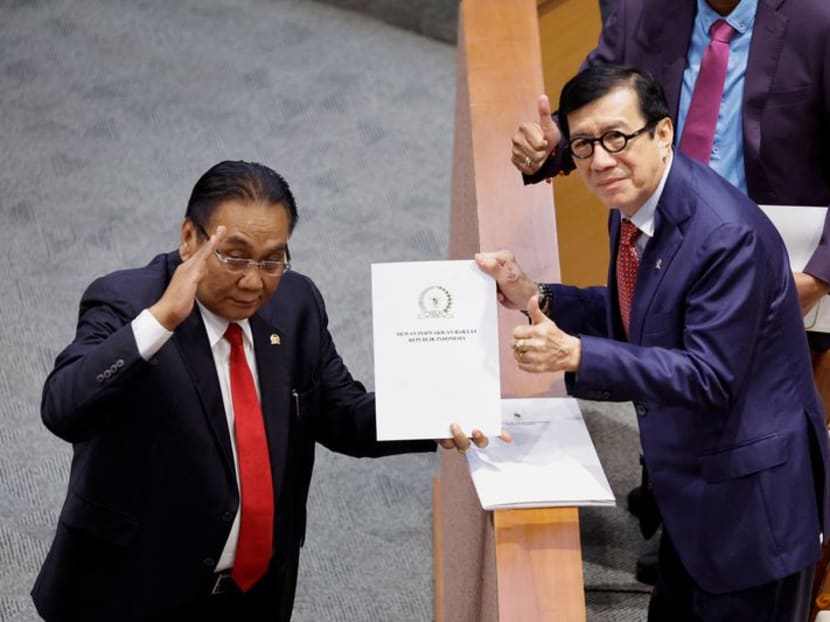 Mr Yasonna Laoly (right), Indonesian Minister of Law and Human Rights, receives the new criminal code report from Mr Bambang Wuryanto (left), head of the parliamentary commission overseeing the revision, during a parliamentary plenary meeting in Jakarta, Indonesia, on Dec 6, 2022. 