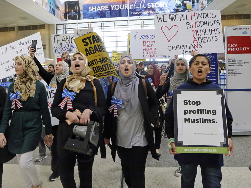 Demonstrators, including women dressed in traditional Muslim head coverings known as hijab, opposed to President Donald Trump's executive orders barring entry to the U.S. by Muslims from seven countries, march through the Tom Bradley International Terminal at Los Angeles International Airport. Photo: AP