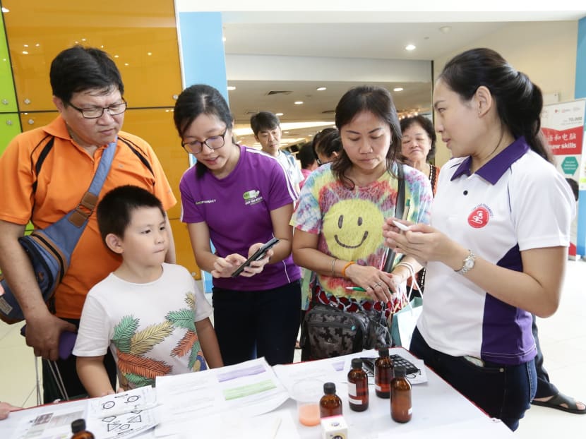 Members of the public speaking to pharmacists at the “Own Your Health @ North West” fair, organised by the Pharmaceutical Society of Singapore and North West Community Development Council. Photo: North West CDC