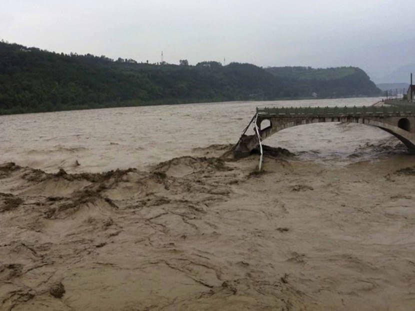 In this image taken by mobile phone camera, what remains of the Qinglian bridge that was swept away by heaving flood waters is seen in the city of Jiangyou in the western province of Sichuan on Tuesday, July 9, 2013. Photo: AP