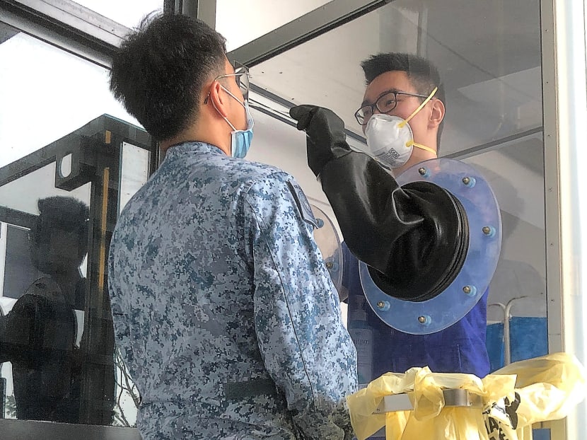 Servicemen from the Republic of Singapore Air Force giving a demonstration at the outdoor swab testing booth of a new medical centre at Tengah Air Base.