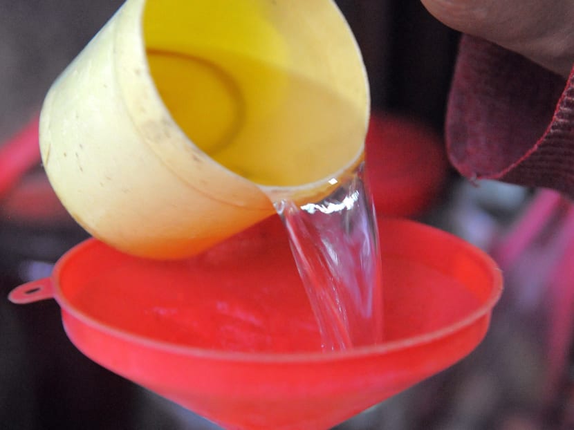 A Cambodian woman decants rice wine into a water bottle for sale in Phnom Penh, Cambodia on Oct 18, 2010.