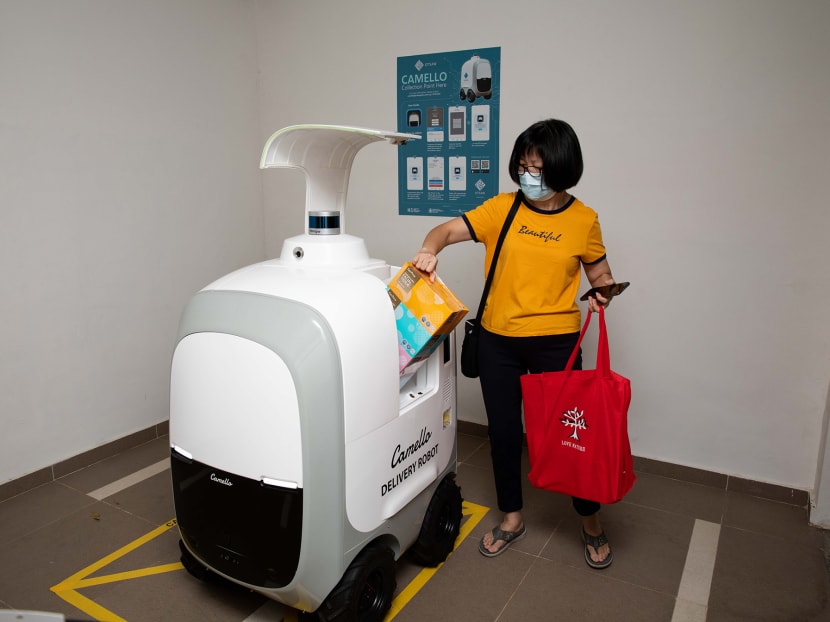 Ms Christine Chong, a resident in Punggol Drive, collecting her groceries at the delivery point for the Camello robot, located at the void deck of the housing block.