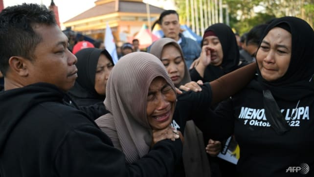 Indonesians pay tribute to victims of stadium crush, fires set on pitch