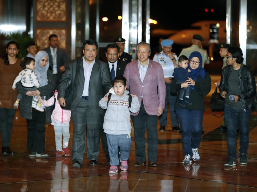 Malaysian stranded in Pyongyang walks with Foreign minister Anifah Aman after arriving at Kuala Lumpur International airport in Sepang, Malaysia, Friday, March 31, 2017. Malaysia said Thursday it has agreed to release the body of Kim Jong Nam to North Korea in exchange for the return of nine Malaysians held in the North's capital. Photo: AP