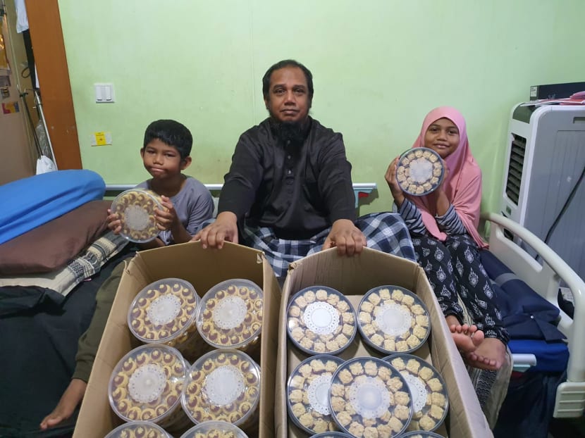 Mr Muhammad Nur with two of his children. He has 100 boxes of snacks he ordered for the Hari Raya Puasa festive period that are unsold.