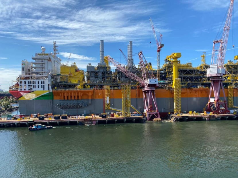 A shore crane leaning against a berthed vessel at Keppel Shipyard in Tuas. Two workers fell into the sea after the crane toppled on Aug 22, 2022.