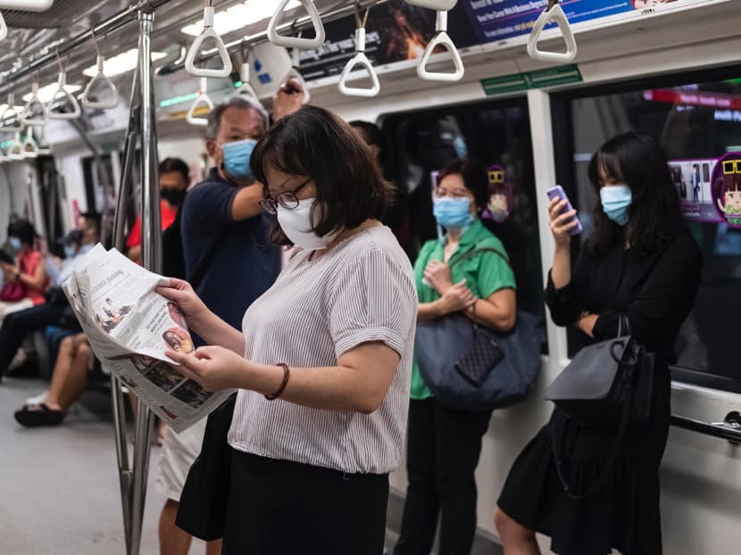 A commuter reads a newspaper on the train. A commuter reads a newspaper on the train.