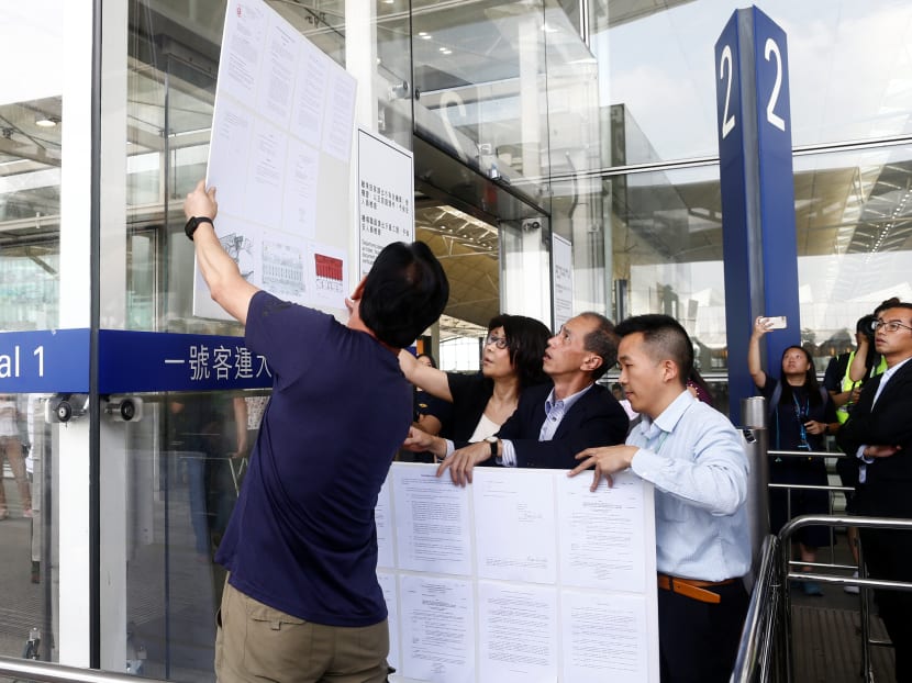 Photo of the day: Officials post a court injunction to stop protesters from obstructing airport operations at an entrance to Hong Kong International Airport on Aug 14, 2019, after hundreds of flights were halted for the second day in a row.
