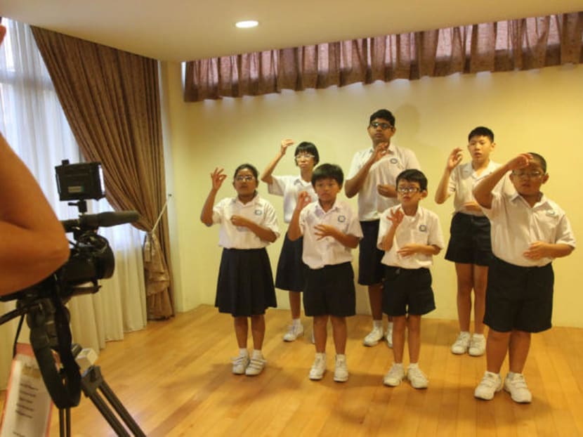 Here, a group of students from Singapore School for the Deaf were signing the National Anthem in front of a recording video. From 2018, deaf students who use sign language can enrol in a mainstream primary school. Currently, they enrol in one of two Special Education schools. TODAY file photo.