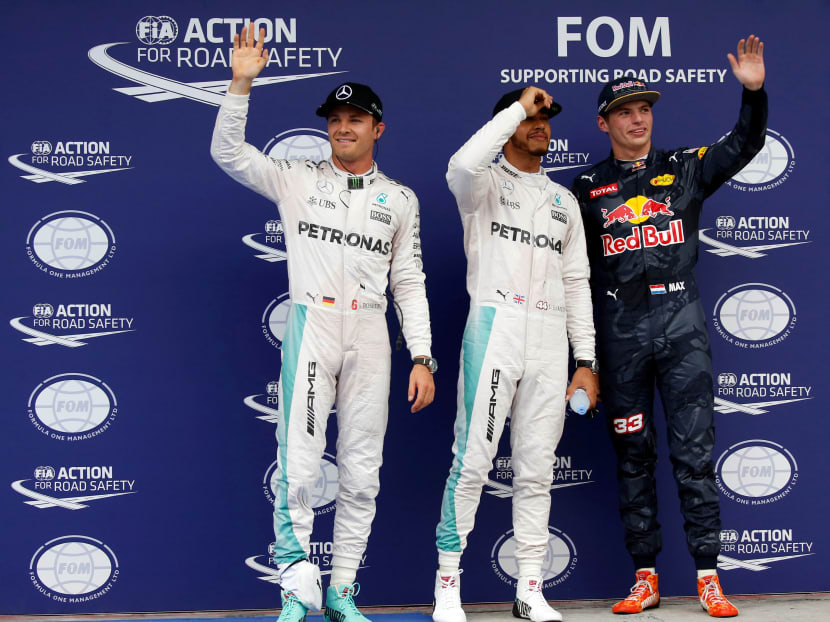Mercedes' Lewis Hamilton of Britain celebrates pole position next to Mercedes' Nico Rosberg of Germany and Red Bull's Max Verstappen of the Netherlands. Photo: Reuters