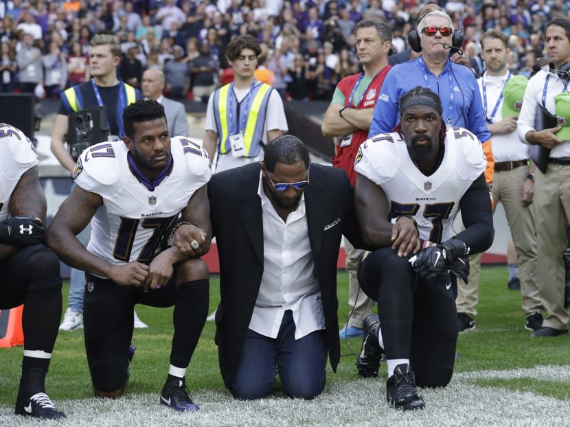 (From left) Baltimore Ravens wide receiver Mike Wallace, former player Ray Lewis and inside linebacker C.J. Mosley locking arms and kneeling down during the playing of the US national anthem before an NFL football game against the Jacksonville Jaguars at Wembley Stadium in London, on Sunday, Sept 24, 2017. Photo: AP