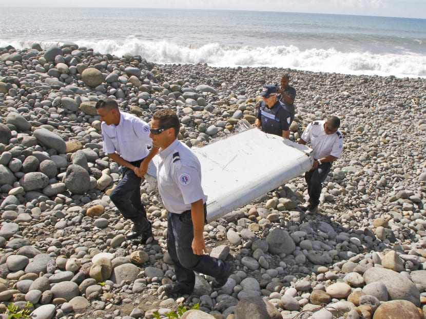 French police officers carrying a piece of plane debris in Saint-Andre, Reunion Island on July 29. Air-safety investigators have identified the component as a “flaperon” from the trailing edge of a Boeing 777. Photo: AP