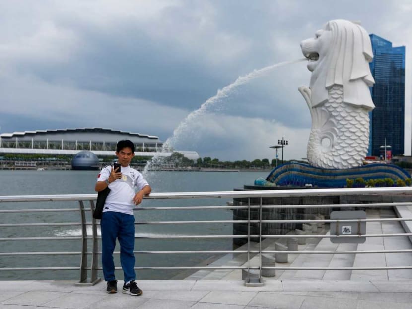 A lone tourist takes a selfie at Merlion Park, in an area that is buzzing with tourists in normal times.