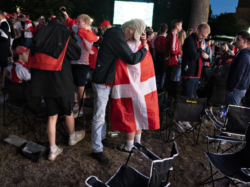 Danish football fans comfort each other at Kildeparken in Aalborg after Denmark was defeated by 2-1 in the Uefa Euro 2020 semi-final football match between England and Denmark on late July 7, 2021.