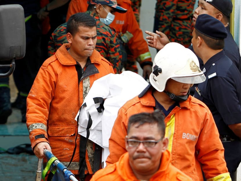Firefighters at the scene of a fire which broke out at the Pusat Tahfiz Darul Quran Ittifaqiyah religious school yesterday. Burnt bodies were found huddled in corners of the rooms. Photo: Reuters