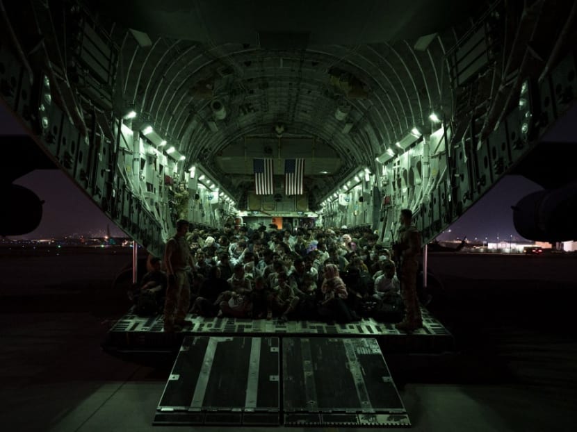 In this image courtesy of the US Air Force, a US Air Force aircrew, assigned to the 816th Expeditionary Airlift Squadron, assists qualified evacuees aboard a US Air Force C-17 Globemaster III aircraft in support of the Afghanistan evacuation at Hamid Karzai International Airport, Kabul, Afghanistan on Aug 21, 2021.