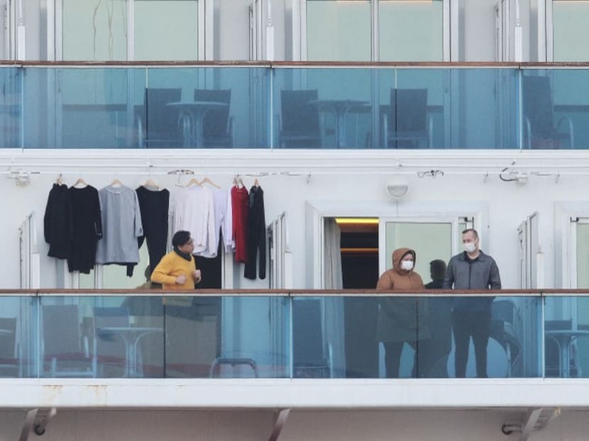 In this file photo taken on Feb 7, 2020, passengers stand on balconies onboard the quarantined Diamond Princess cruise ship at Daikoku Pier Cruise Terminal in Yokohama. A year after the ill-fated ship went into quarantine off Japan, the cruise industry is hoping passengers will help steer them to calmer waters.