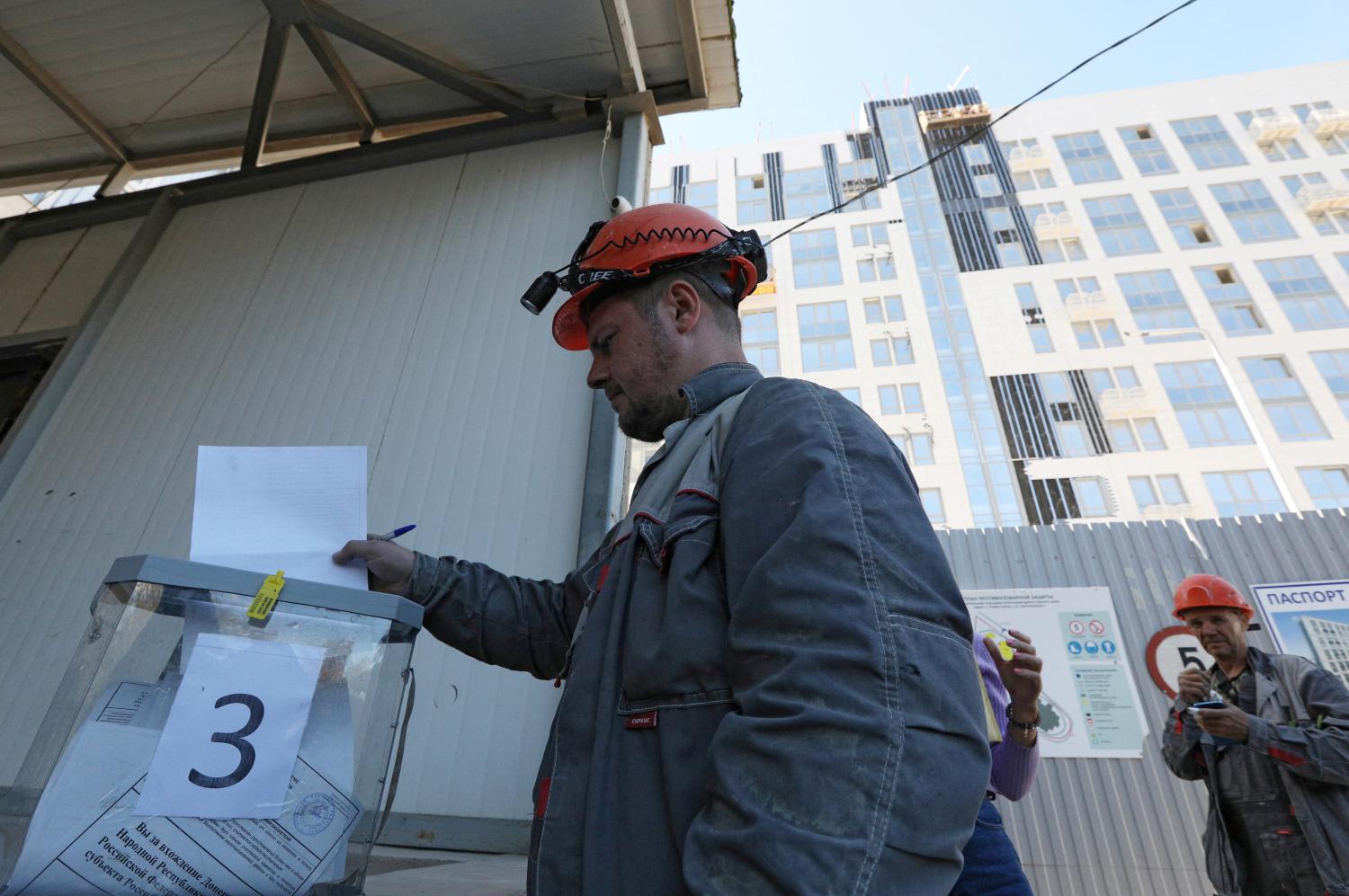 A construction worker casts his ballot during a referendum on the joining of the self-proclaimed Donetsk People's Republic (DPR) to Russia, in Sevastopol, Crimea Sept 26, 2022.