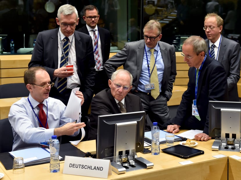 German Finance Minister Wolfgang Schaeuble (C) chats with unidentified officials during a euro zone finance ministers' meeting on the situation in Greece, in Brussels, Belgium, July 12, 2015.  Photo: Reuters