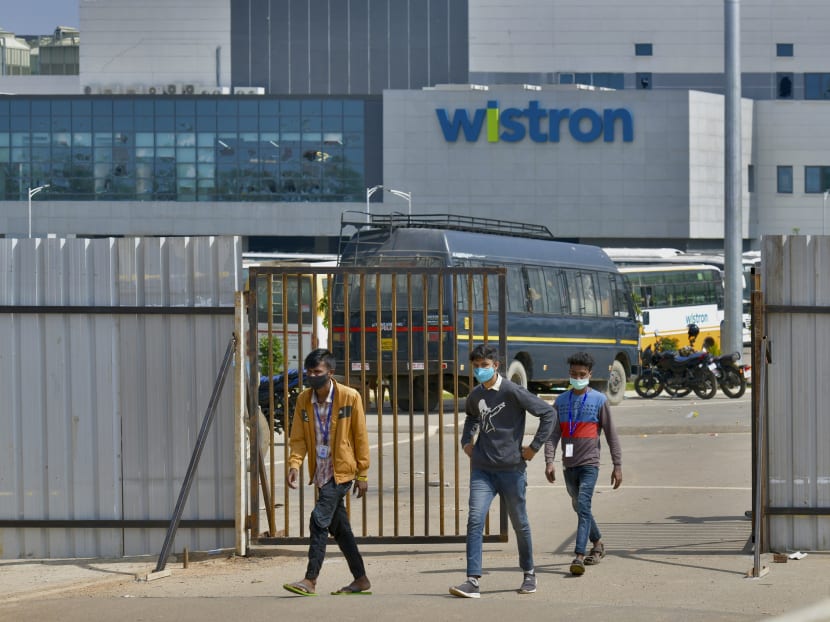 People exit from the gate of Wistron, a Taiwanese-run iPhone factory at Narsapura, about 60 km from Bangalore on Dec 13, 2020.