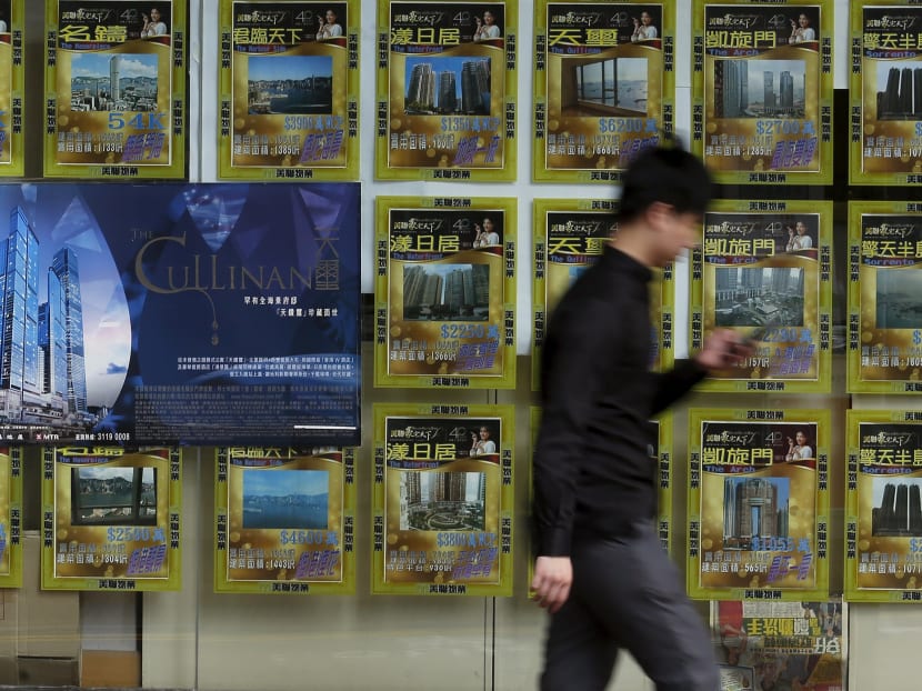 A man walks past a property agent advertising luxury homes in West Kowloon in Hong Kong on July 2, 2015. Photo: Reuters