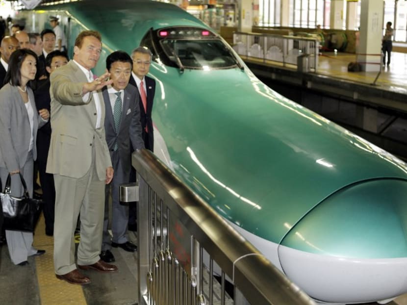 This file photo shows former California Governor Arnold Schwarzenegger (2nd-L) and Masaki Ogata (2nd-R), vice president of East Japan Railway Co, during an inspection tour of Japan's high-speed train operations in Saitama on September 14, 2010. Photo: AFP
