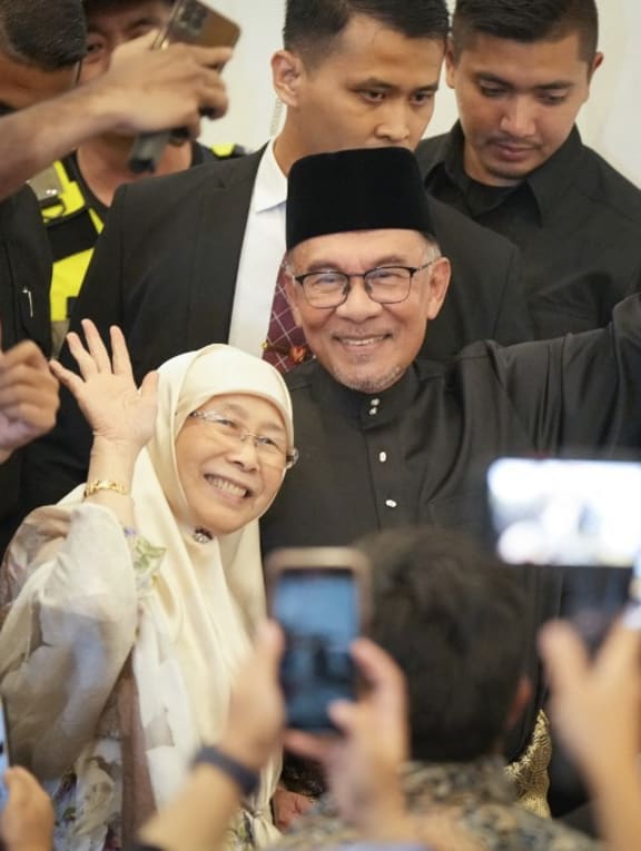 Malaysia's newly appointed prime minister Anwar Ibrahim and his wife Wan Azizah waving as they arrive ahead of his press conference in Kuala Lumpur, Malaysia on Nov 24, 2022. 