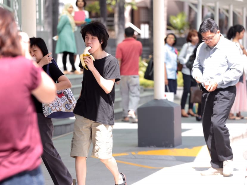 Amos Yee eating a banana as he enters the State Courts for his pre-trial conference on April 17, 2015. Photo: Jason Quah
