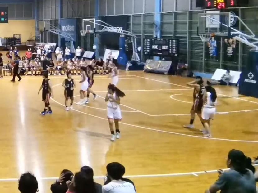Players react after what appears to be a ceiling light crashes to the ground in front of a scorer's table during a Pennant Cup match at the Singapore Basketball Centre on Nov 12, 2022. 