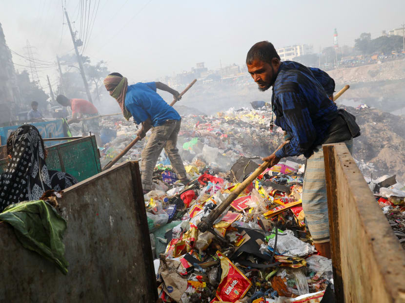 Workers dump waste in the bank of Buriganga River in Dhaka, Bangladesh, on Jan 2, 2020. Workers dump waste in the bank of Buriganga River in Dhaka, Bangladesh, on Jan 2, 2020.