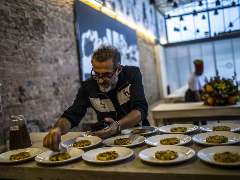 The Italian chef Massimo Bottura sprinkles spices onto Mediterranean-style couscous before it is served to the guests at Refettorio Gastromotiva, a feeding center in Rio de Janeiro, Aug 11, 2016. Photo: The New York Times
