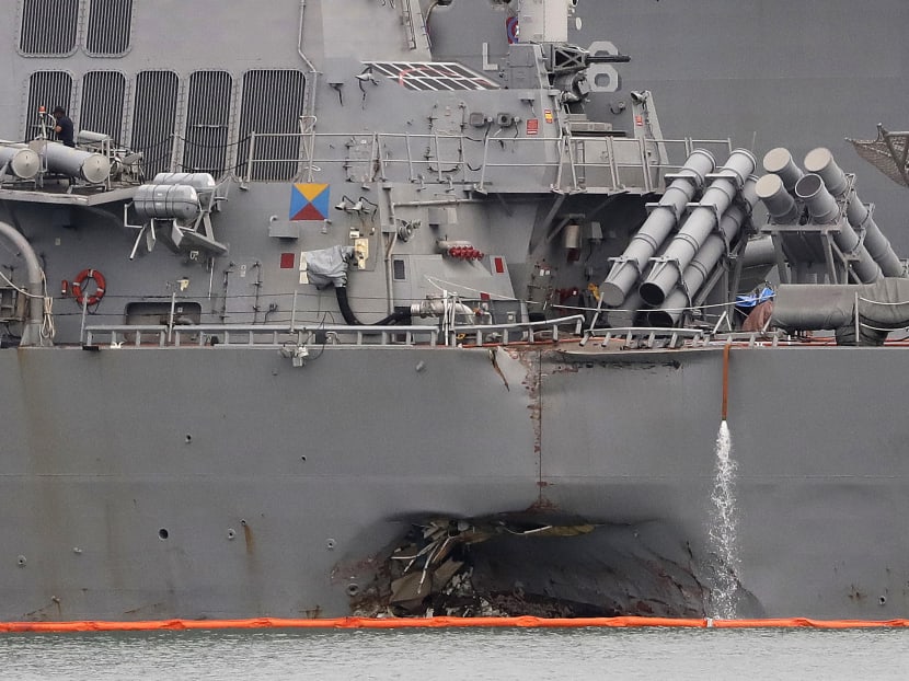 The damaged port aft hull of USS John S. McCain, is seen while docked at Singapore's Changi naval base. Photo: AP