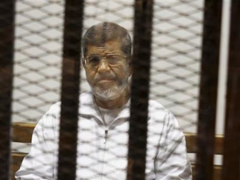 In this May 8, 2014 file photo, Egypt's ousted Islamist President Mohammed Morsi sits in a defendant cage in the Police Academy courthouse in Cairo, Egypt. Photo: AP