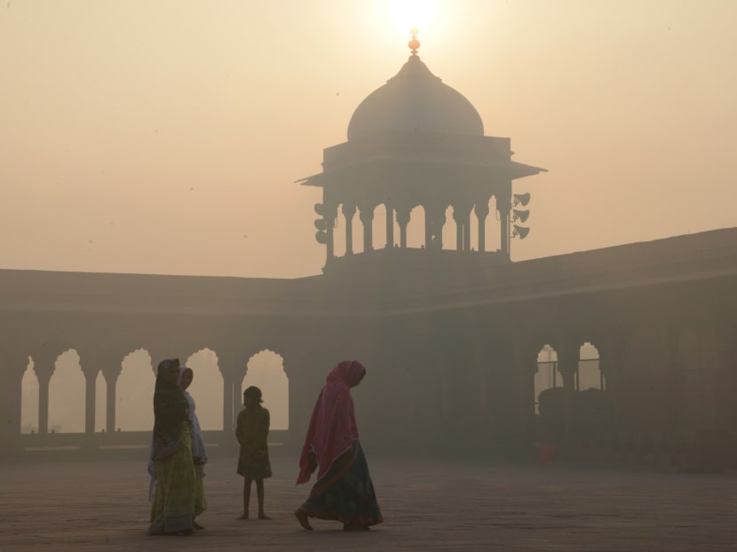 This file photo taken on Nov 3, 2016 shows Indian women walking as smog envelops the Jama Masjid mosque in the old quarters of New Delhi. Photo: AFP