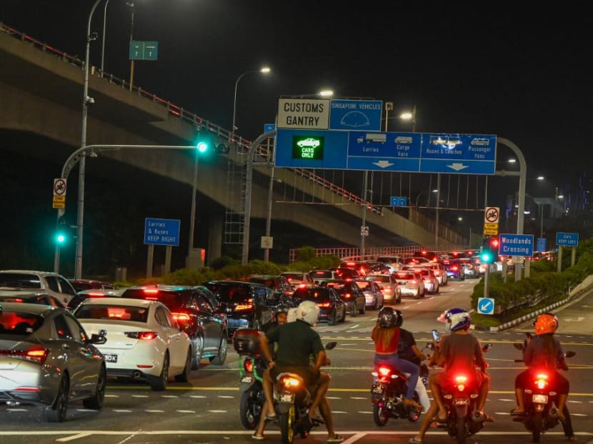 Vehicles form a long queue to enter the Woodlands Checkpoint in Singapore early on April 1, 2022, before crossing the causeway to Malaysia's southern Johor state, as both countries reopen its borders to all fully vaccinated travellers.