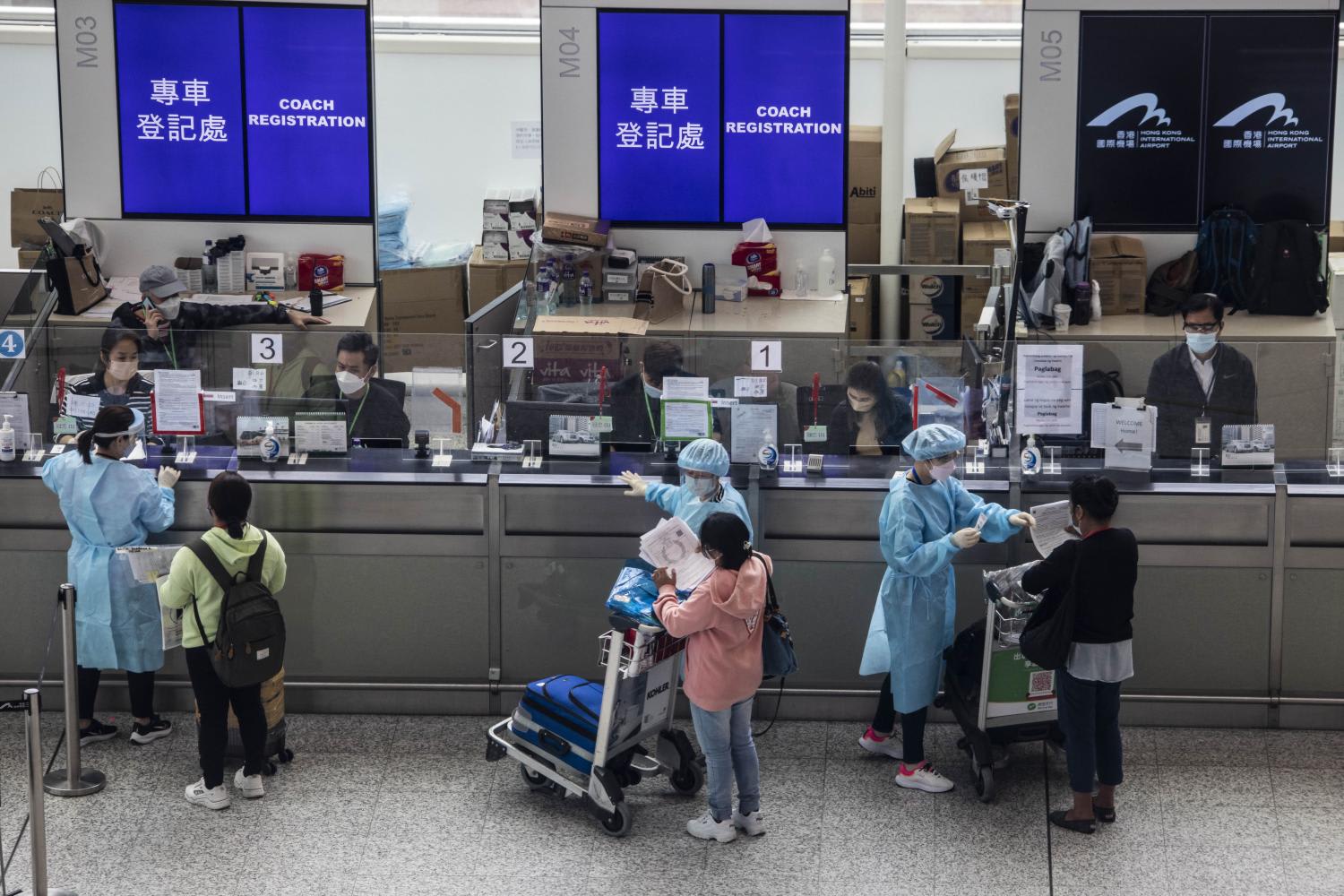 Passengers register to be taken to hotel quarantine at the Hong Kong International Airport on April 1, 2022, after the city lifted a flight ban on nine countries amid the pandemic.