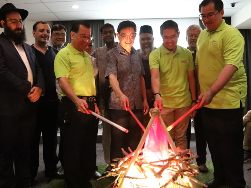 Deputy Prime Minister Heng Swee Keat (first row, third from right) lighting a “fire” before a fireside chat at The Harmony in Diversity Gallery.