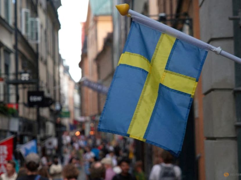 FILE PHOTO: A Swedish flag hangs outside a store on a busy street as visitors walk past in the background in the old town of Stockholm, Sweden, July 14, 2023 REUTERS/Tom Little/File Photo