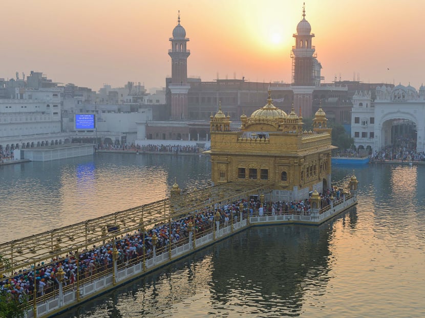 Indian Sikh devotees pay respect in the early morning during Diwali Festival at the illuminated Golden Temple in Amritsar on Thursday. Diwali, the Hindu festival of lights, marks the triumph of good over evil, and commemorates the return of Hindu deity Rama to his birthplace Ayodhya after victory against the demon king Ravana. Photo: AFP