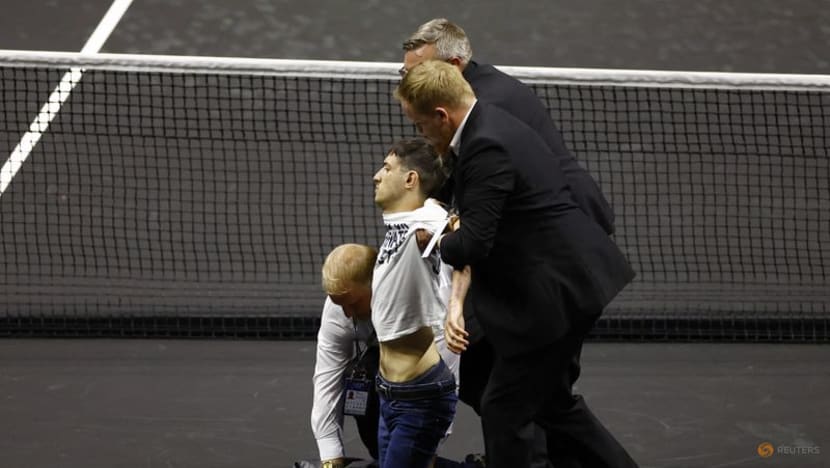 Laver Cup match briefly halted after protester sets arm on fire on court
