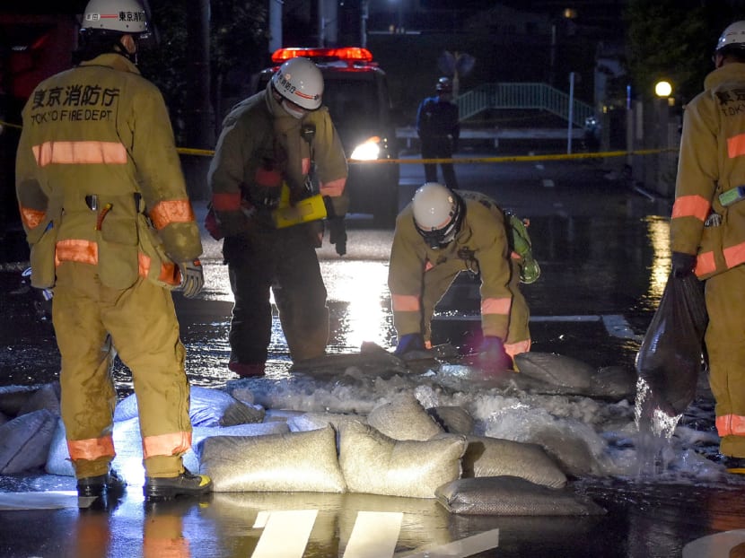 Members of the Tokyo Fire Department try to fix a broken water pipe in Tokyo on Oct 7, 2021 after a 6.1-magnitude earthquake shook the Japanese capital and surrounding areas.