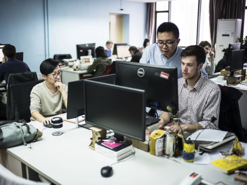 Sixth Tone editor Wei Xing (centre) works with newsroom employees at the English-language version of The Paper, a digital success in China overseen by the Chinese Communist Party. Photo: The New York Times