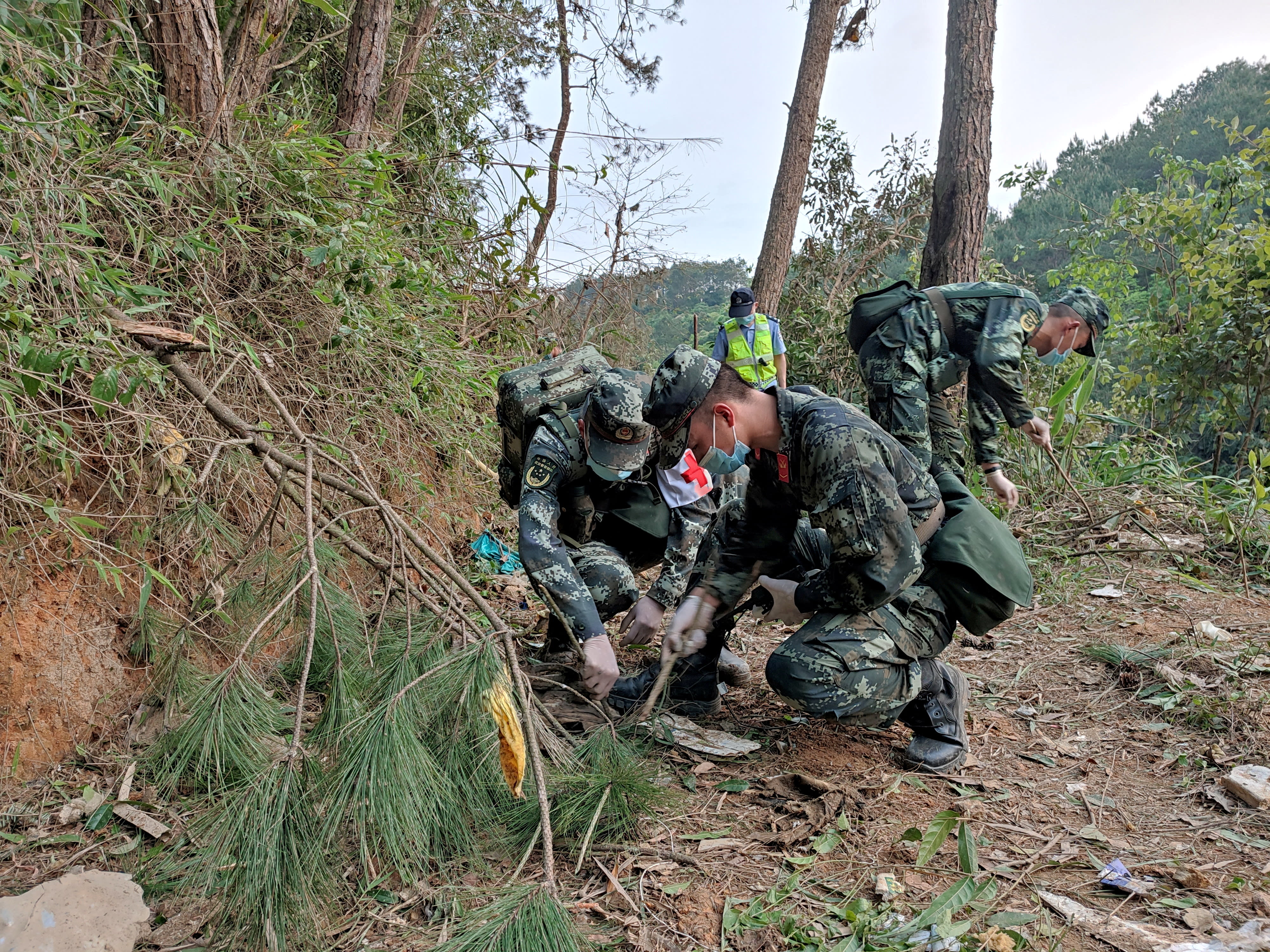 Paramilitary police officers work at the site where a China Eastern Airlines Boeing 737-800 plane flying from Kunming to Guangzhou crashed, in Wuzhou, on March 21, 2022.