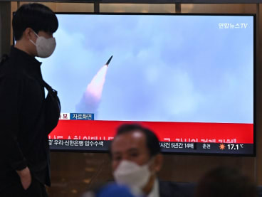 A man walks past a television screen showing a news broadcast with file footage of a North Korean missile test, at a railway station in Seoul on Sept 29, 2022.