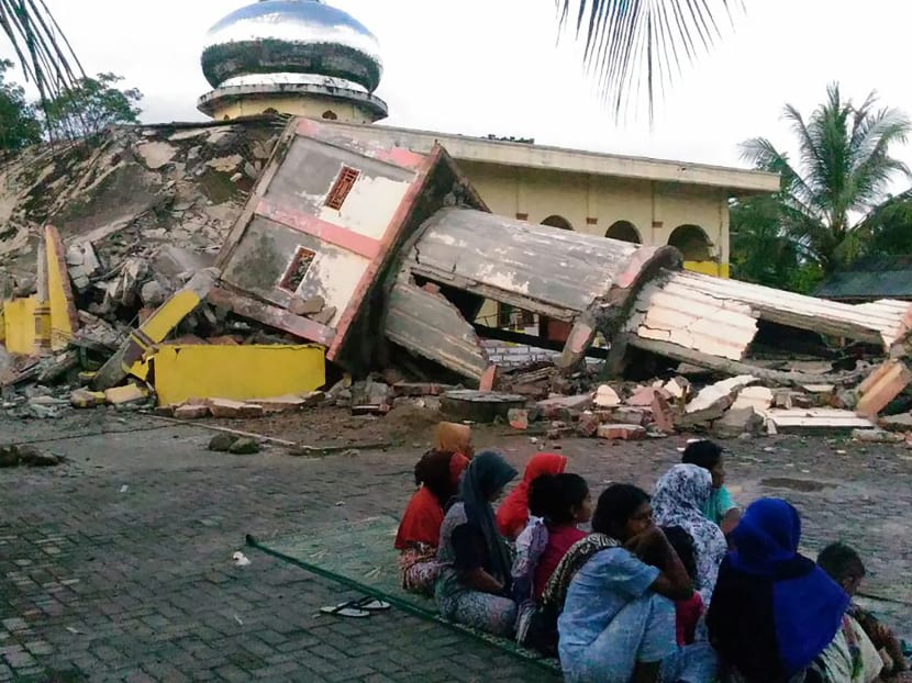 Residents gather around a collapsed building after an earthquake struck the town of Pidie, Indonesia's Aceh province in northern Sumatra, on Dec 7, 2016. Photo: AFP