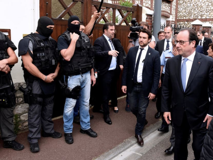 French President Francois Hollande (right) meeting members of the national police intervention 

group outside the church in Normandy yesterday. The country is in a state of high alert. Photo: Reuters